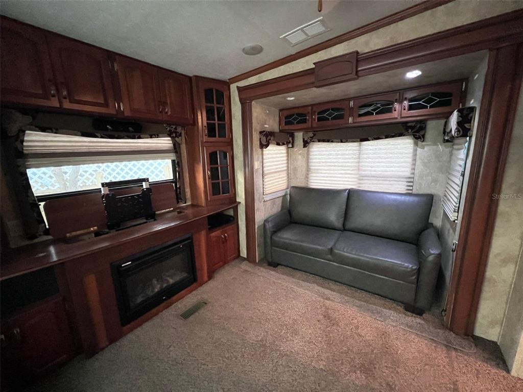 3000 Clarcona Road, Unit 343 Apopka, FL 32703 - Photo 7 of 15 a living room with furniture a flat screen tv and a fireplace