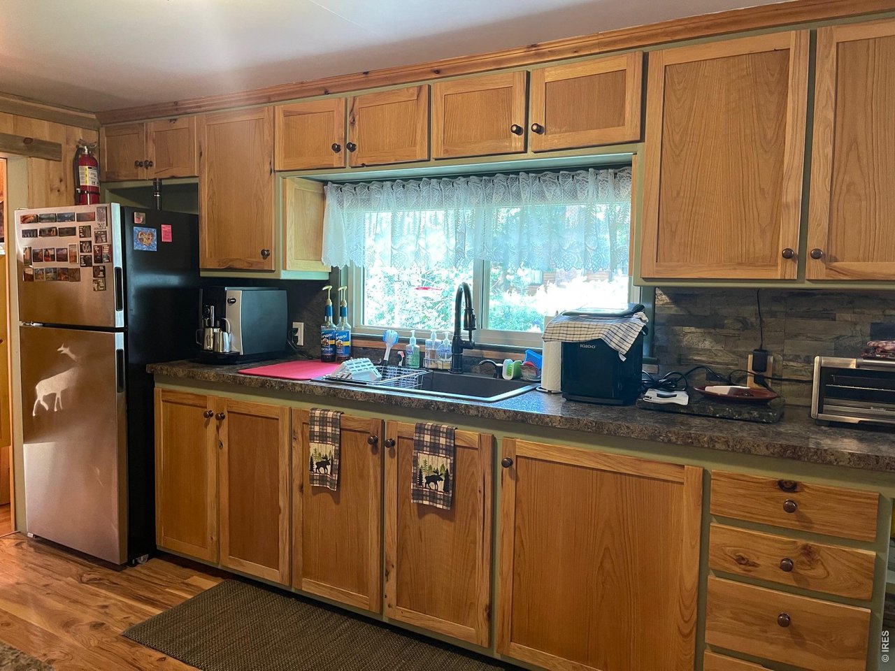 124 Ski Road Allenspark, CO 80510 - Photo 19 of 29 a kitchen with stainless steel appliances granite countertop a sink a stove and a refrigerator