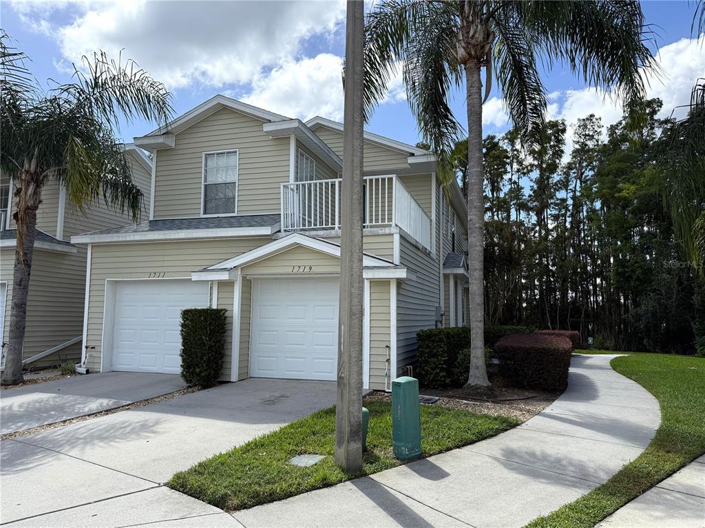 a front view of a house with a yard and palm trees