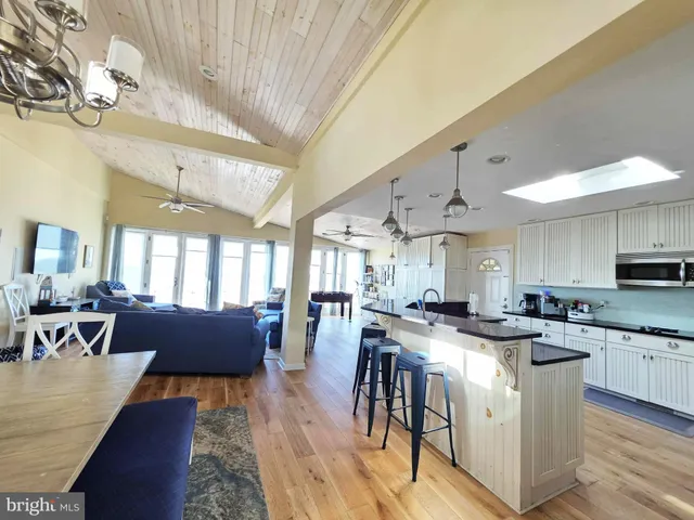 a kitchen with stainless steel appliances granite countertop wooden floors stove top oven and cabinets
