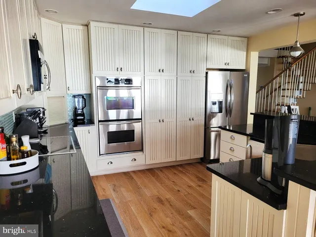 a kitchen with stainless steel appliances a refrigerator and a stove top oven