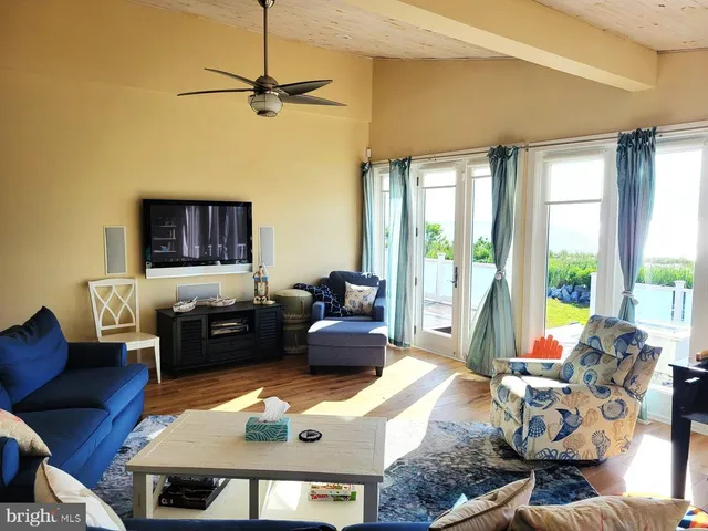 a living room with furniture a large window and a flat screen tv
