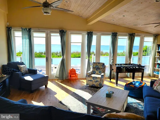 a living room with furniture and floor to ceiling windows