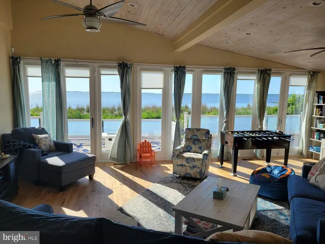 a living room with furniture and floor to ceiling windows