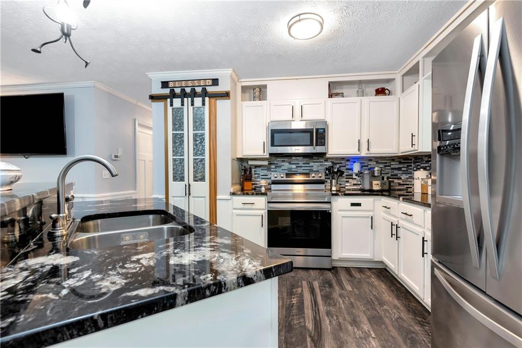 90 Old City Park Road Lavonia, GA 30553 - Photo 14 of 41 a kitchen with stainless steel appliances granite countertop a stove a sink and a refrigerator