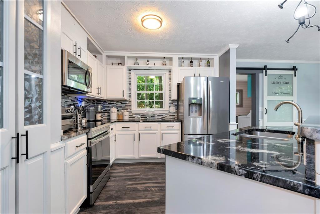 90 Old City Park Road Lavonia, GA 30553 - Photo 16 of 41 a kitchen with stainless steel appliances granite countertop a refrigerator a stove and a sink with wooden floor