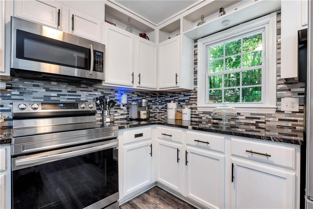 90 Old City Park Road Lavonia, GA 30553 - Photo 17 of 41 a kitchen with granite countertop a stove a sink and a microwave