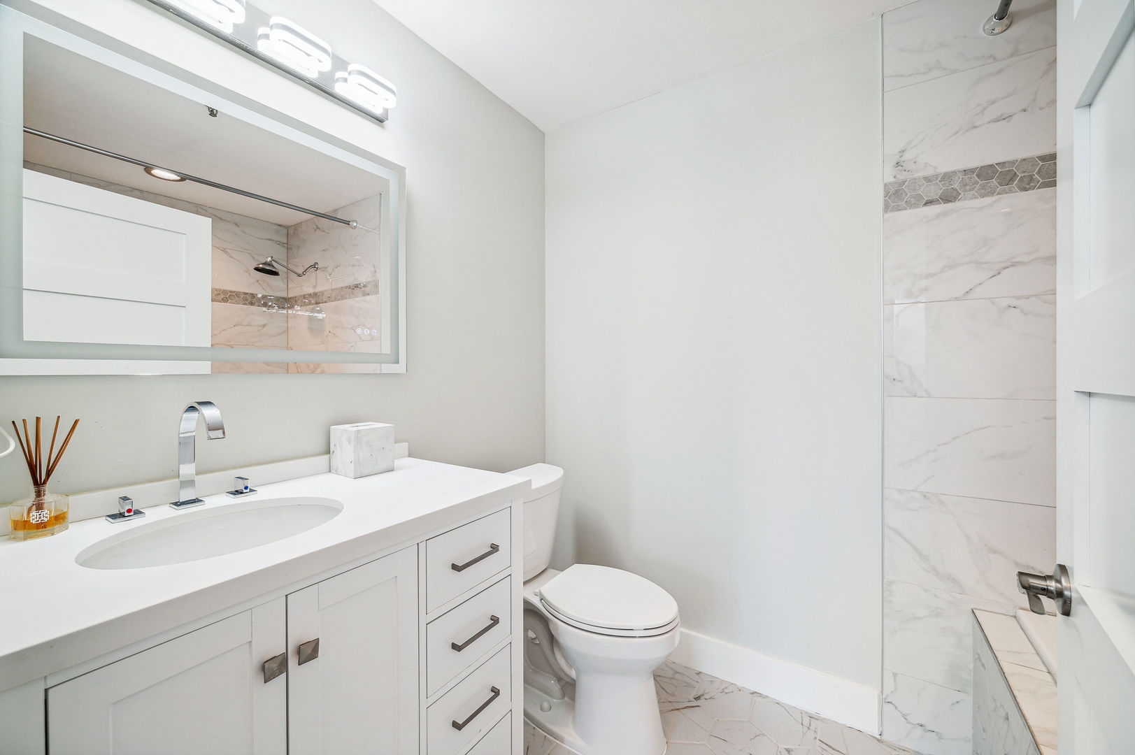 701 South Wells Street, Unit 903 Chicago, IL 60607 - Photo 14 of 20 a bathroom with a sink a toilet a mirror and shower