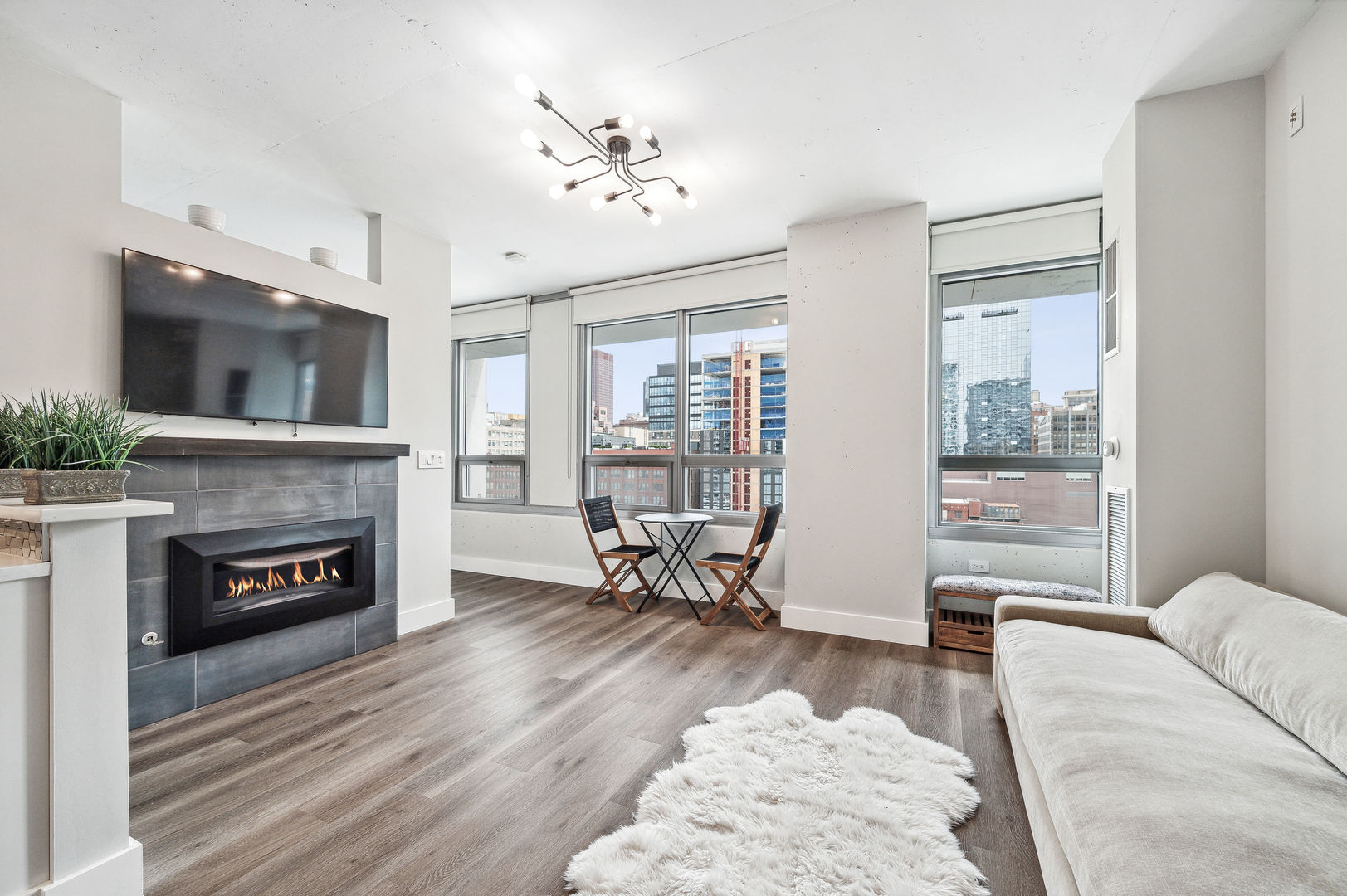 701 South Wells Street, Unit 903 Chicago, IL 60607 - Photo 3 of 20 a living room with furniture a fireplace and a flat screen tv