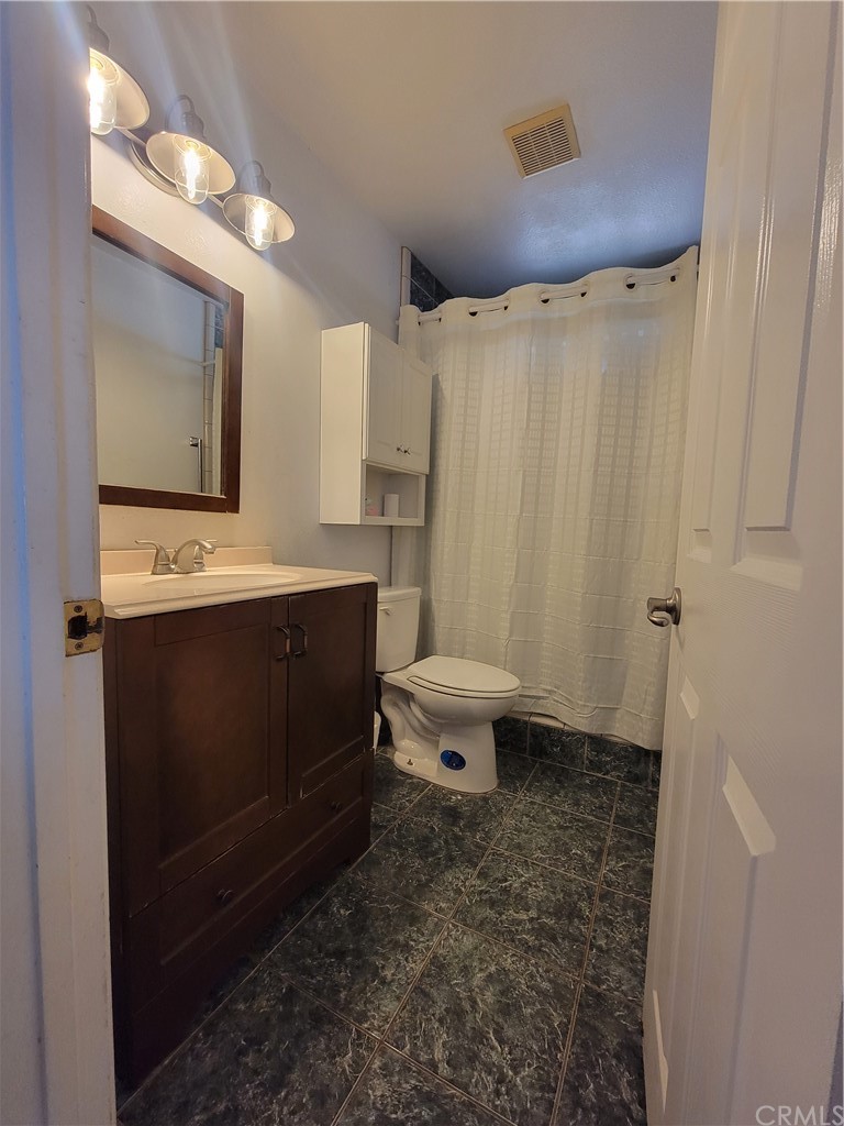 8381 Verde Ridge Road Spring Valley, CA 91977 - Photo 17 of 30 a bathroom with a sink a toilet and mirror