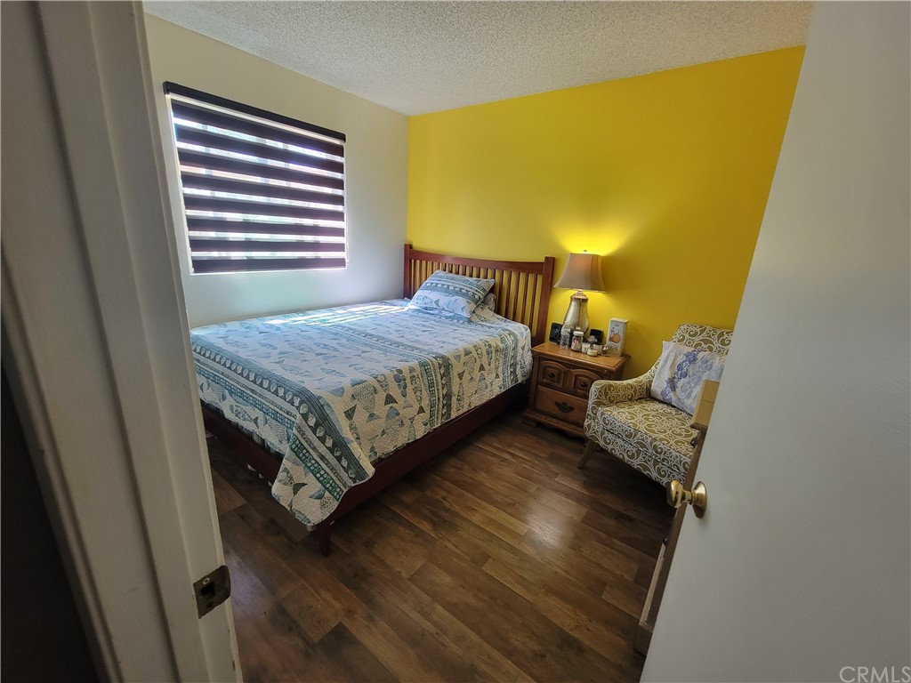 8381 Verde Ridge Road Spring Valley, CA 91977 - Photo 19 of 30 a bedroom with a bed and wooden floor