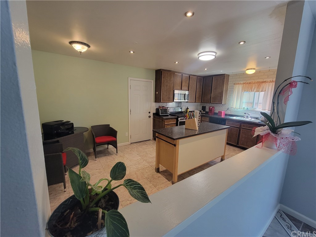 8381 Verde Ridge Road Spring Valley, CA 91977 - Photo 5 of 30 a kitchen with stainless steel appliances a sink a stove a refrigerator cabinets and living room view