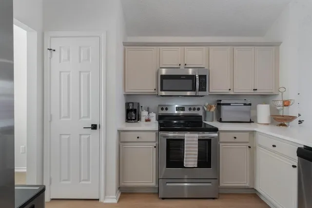 a kitchen with white cabinets and stainless steel appliances