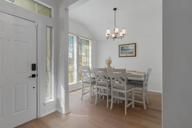 a view of a dining room with furniture wooden floor and a chandelier
