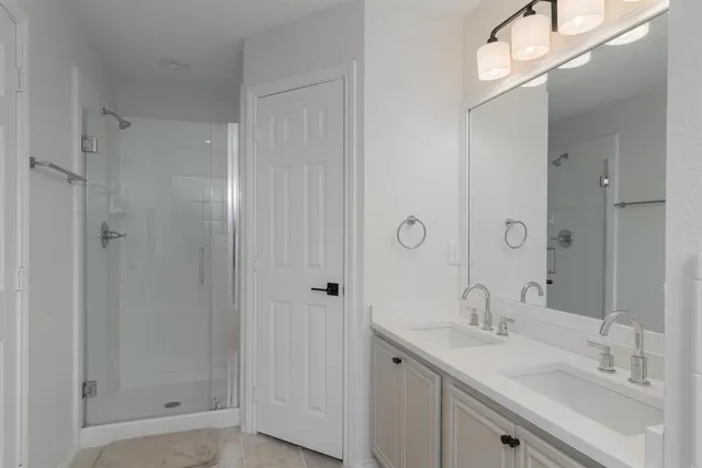 a bathroom with a shower sink vanity and mirror