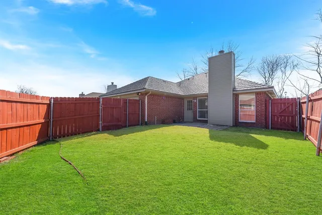 a view of a backyard with wooden fence