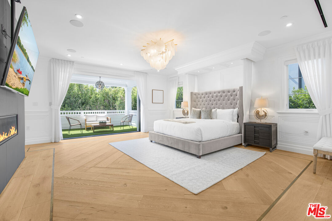 843 North Spaulding Avenue Los Angeles, CA 90046 - Photo 12 of 24 a bedroom with a large bed and a flat tv screen on dresser