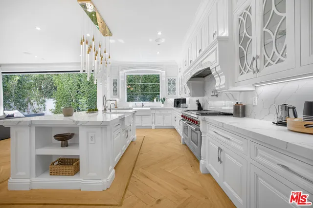 a large kitchen with stainless steel appliances granite countertop a stove a sink and a refrigerator