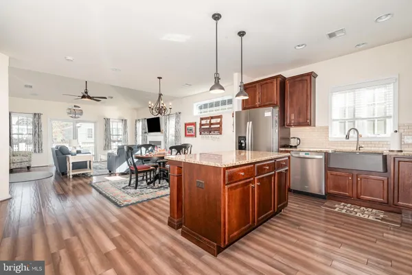 a kitchen with stainless steel appliances granite countertop wooden floors and white cabinets