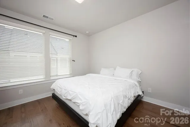 a large bed sitting in a bedroom next to a window