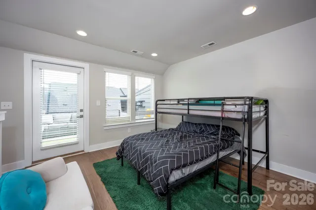 a bedroom with a bed a window and chair