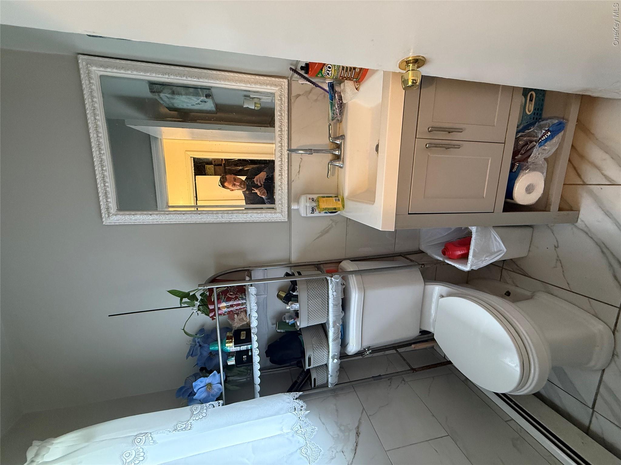 22 Slinn Avenue Spring Valley, NY 10977 - Photo 8 of 11 a bathroom with a sink toilet and mirror
