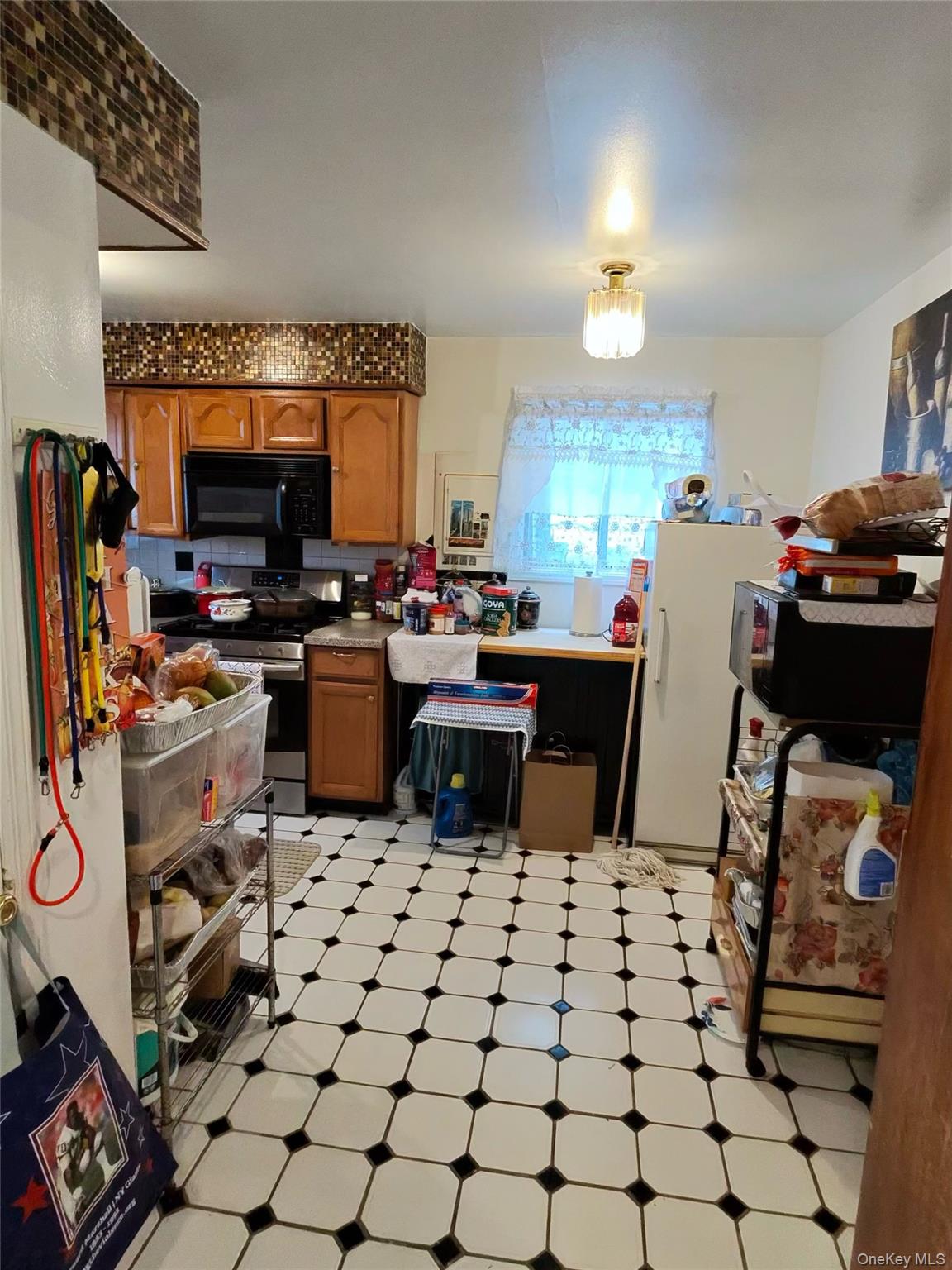 22 Slinn Avenue Spring Valley, NY 10977 - Photo 9 of 11 a kitchen with a sink a stove and a microwave