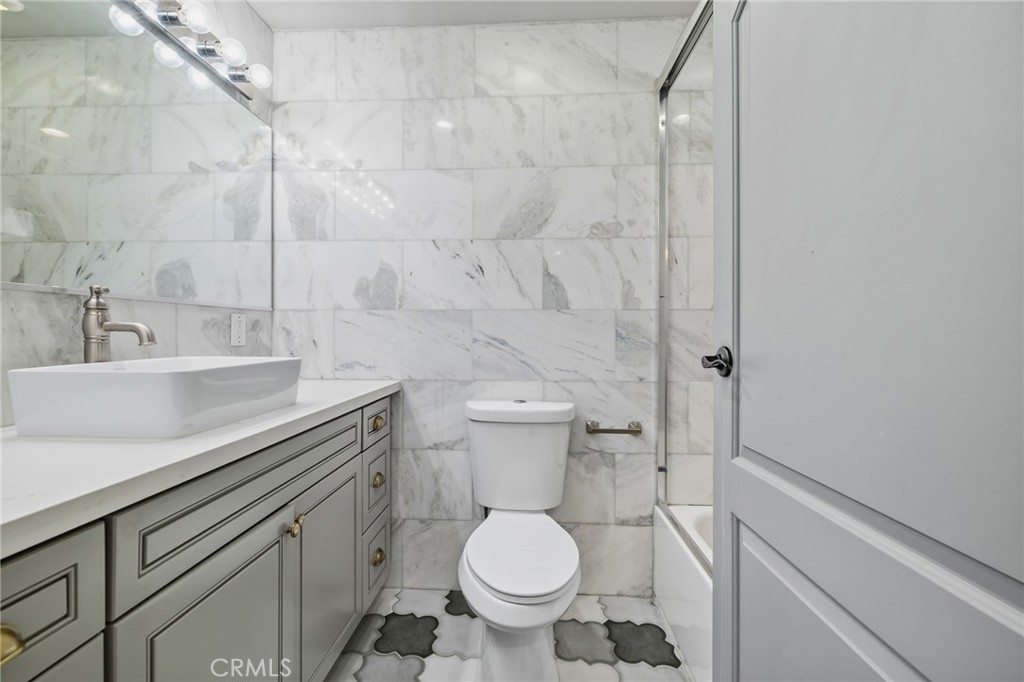 17153 Rayen Street Northridge, CA 91325 - Photo 25 of 75 a bathroom with a granite countertop toilet and a sink