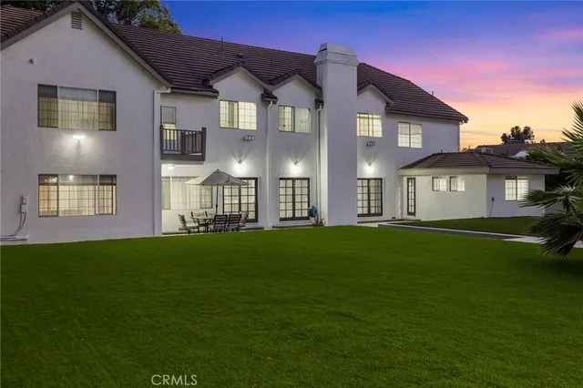 a view of a house with backyard and a tree