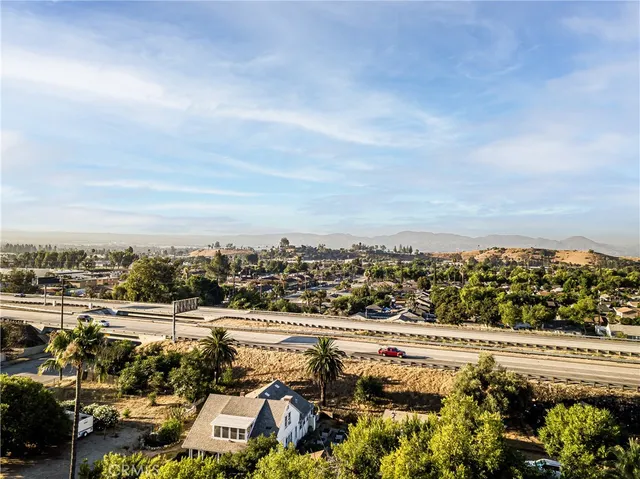an aerial view of a house with a yard and a large tree
