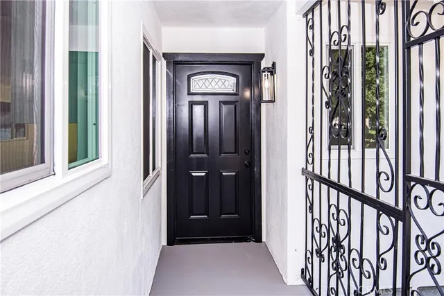 a kitchen with stainless steel appliances granite countertop a sink dishwasher a refrigerator and white cabinets with wooden floor