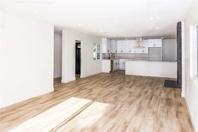 a large white kitchen with a sink and dishwasher a oven with white cabinets