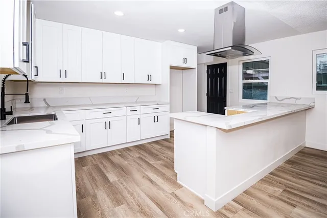 an empty room with wooden floor a ceiling fan and windows
