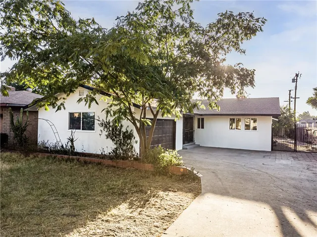 a view of a house with a tree and a yard