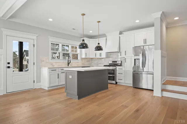 a kitchen with stainless steel appliances a stove a refrigerator and cabinets