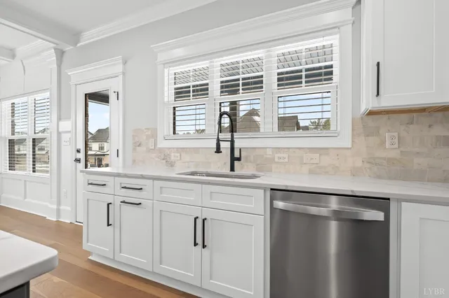 a kitchen with stainless steel appliances kitchen island granite countertop a sink a stove and a wooden floors