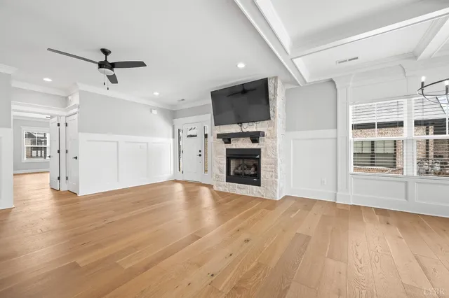 a large kitchen with kitchen island a stove a sink dishwasher and white cabinets with wooden floor