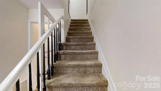 an empty room with wooden floor closet and windows