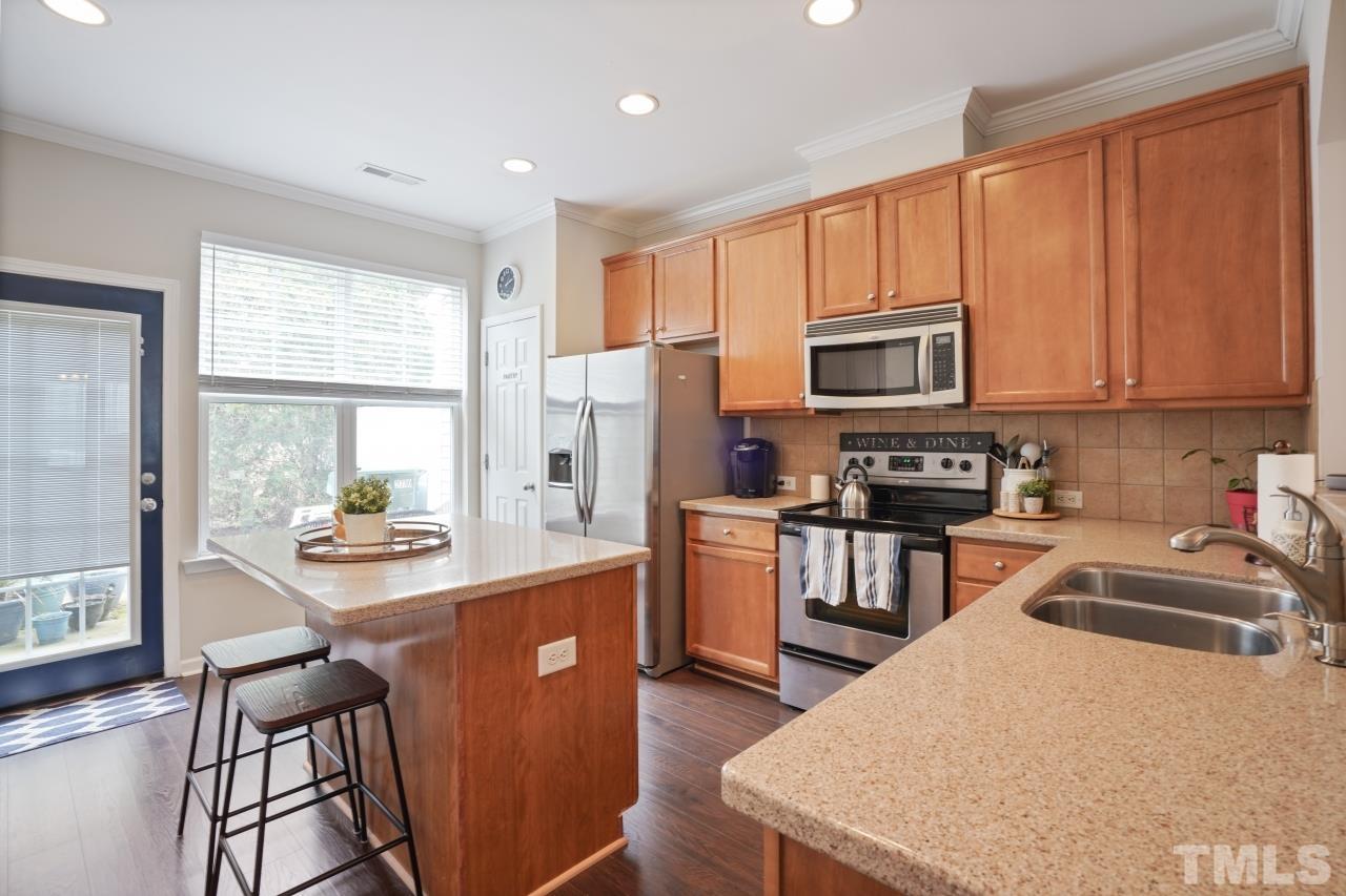 2710 Chilton Place Raleigh, NC 27616 - Photo 11 of 25 a kitchen with stainless steel appliances granite countertop a refrigerator a stove top oven a sink dishwasher and white cabinets with wooden floor