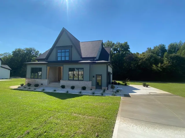a kitchen with stainless steel appliances a sink a stove a refrigerator white cabinets and wooden floor