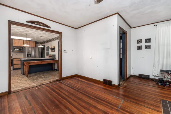 a view of a big room with wooden floor and kitchen