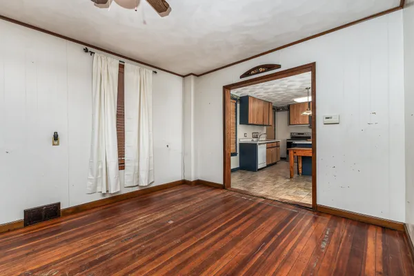 a view of a room with wooden floor and a bathroom