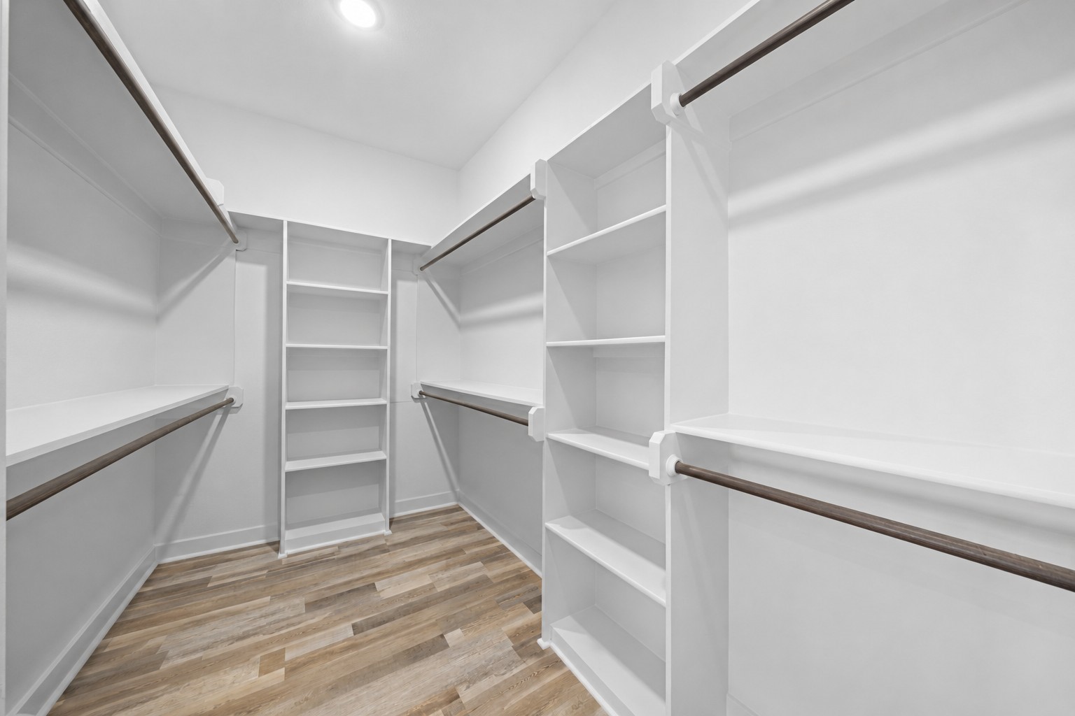 1655 Old Cuero Road Yoakum, TX 77995 - Photo 12 of 24 Virtually Cleaned: This expansive walk-in primary closet is thoughtfully designed with custom built-in shelving, multiple hanging rods, and generous storage throughout to keep your wardrobe neatly organized. Open shelving provides the perfect place for shoes, handbags, and accessories, while abundant hanging space easily accommodates both short and long garments.