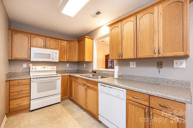 a kitchen with stainless steel appliances granite countertop a sink a stove and cabinets