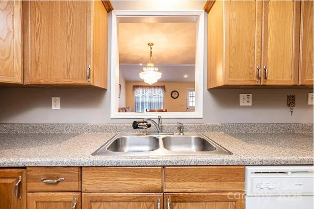 a kitchen with granite countertop a sink a window and cabinets