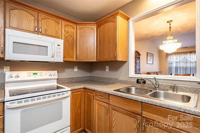 a kitchen with stainless steel appliances granite countertop a sink a stove and cabinets