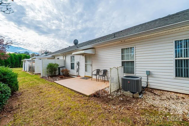 a view of a house with backyard and sitting area