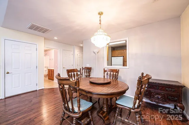 a dining room with furniture a chandelier and wooden floor