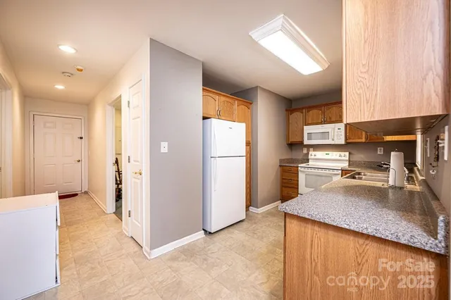 a kitchen with granite countertop a refrigerator and a sink