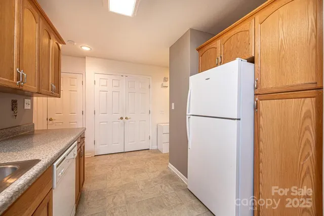 a view of a kitchen with refrigerator and a sink